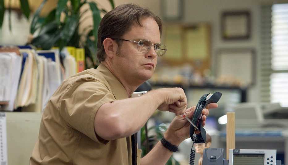 rainn wilson as dwight schrute holding phone and screwdriver in a still from the office