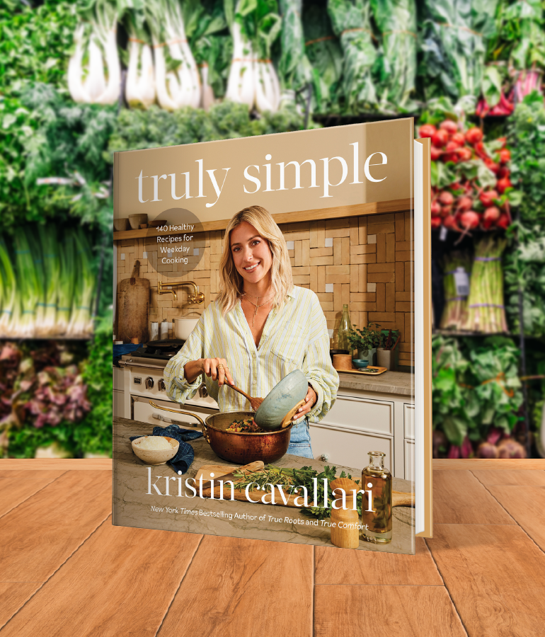 cookbook that says truly simple with kristin cavallari scooping food from a small bowl into a big bowl in a kitchen; on wooden table with vegetables and plants behind it