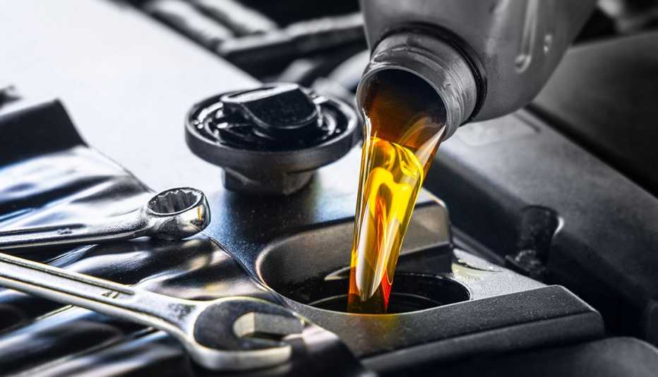 oil being poured into compartment on car