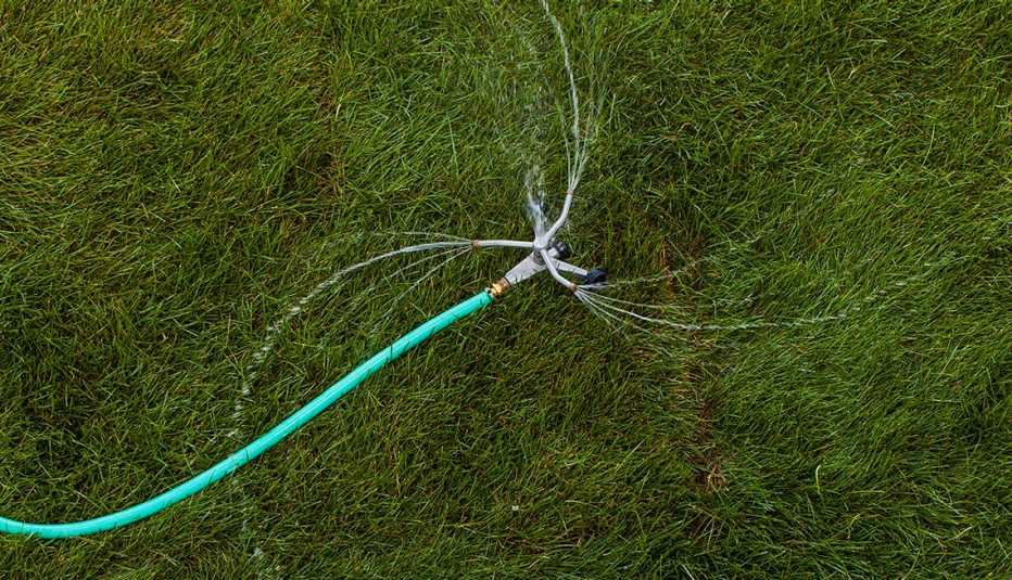 top view of rotating sprinkler spraying water on grass