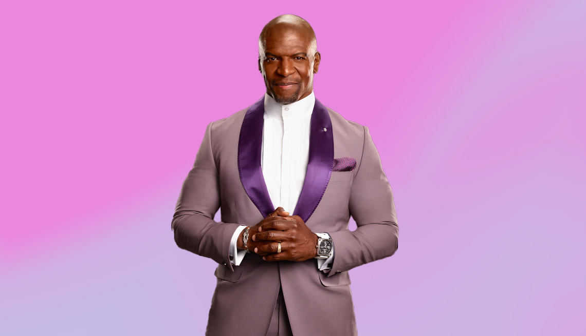 terry crews in tanish suit with purple pocket square, hands clasped together, light purple ombre background