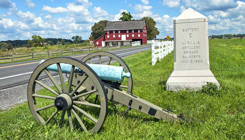 Cannon on wheels next to stone that says Battery E, 1st R I L A, Artillery Brigade, 3rd Corps, July 2 1863