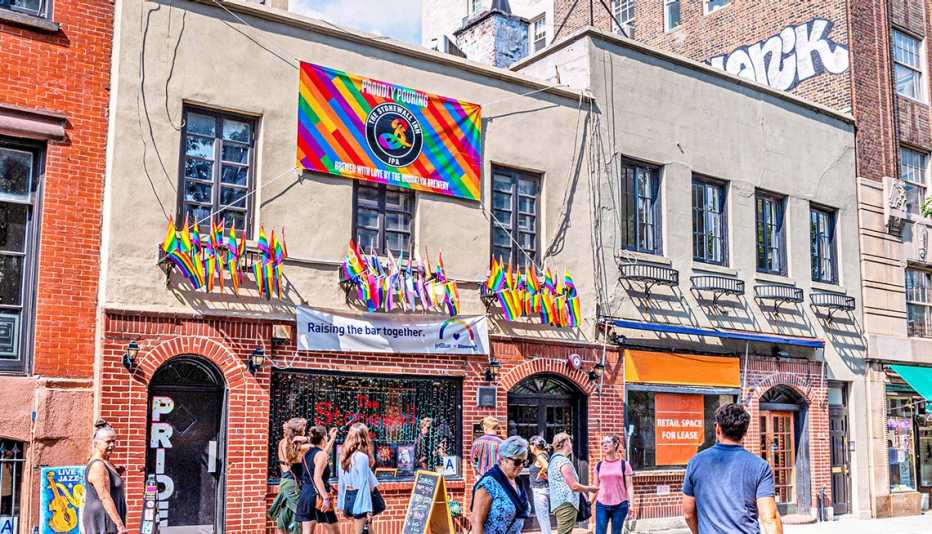 Big building with rainbow banner on it that says proudly pouring, the Stonewall Inn I P A, brewed with love by the Brooklyn Brewery