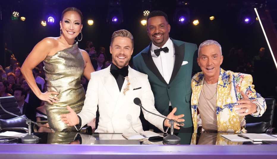 carrie ann inaba, derek hough, alfonso ribeiro and bruno tonioli behind table on dancing with the stars set