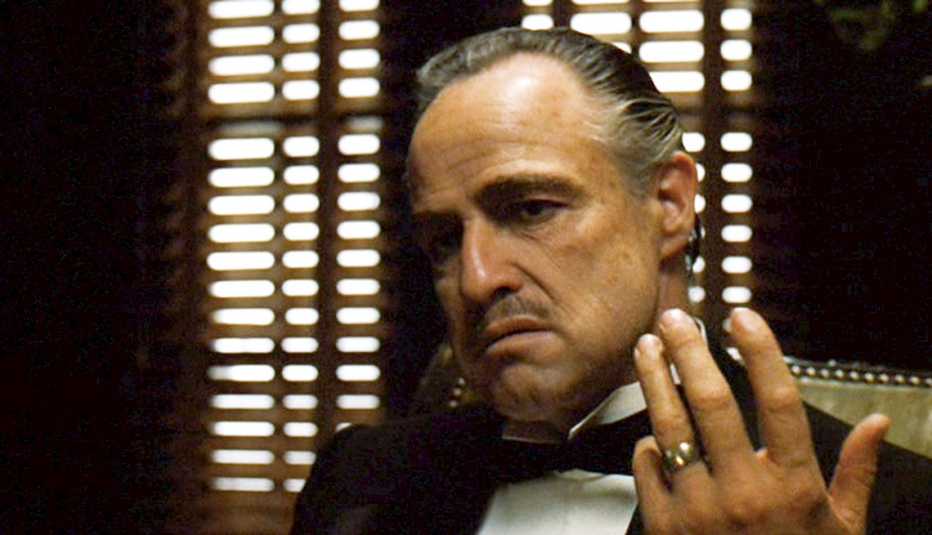 Marlon Brando as Don Vito Corleone, wearing a tuxedo and holding up his hand showing a ring on his ring finger, in The Godfather movie