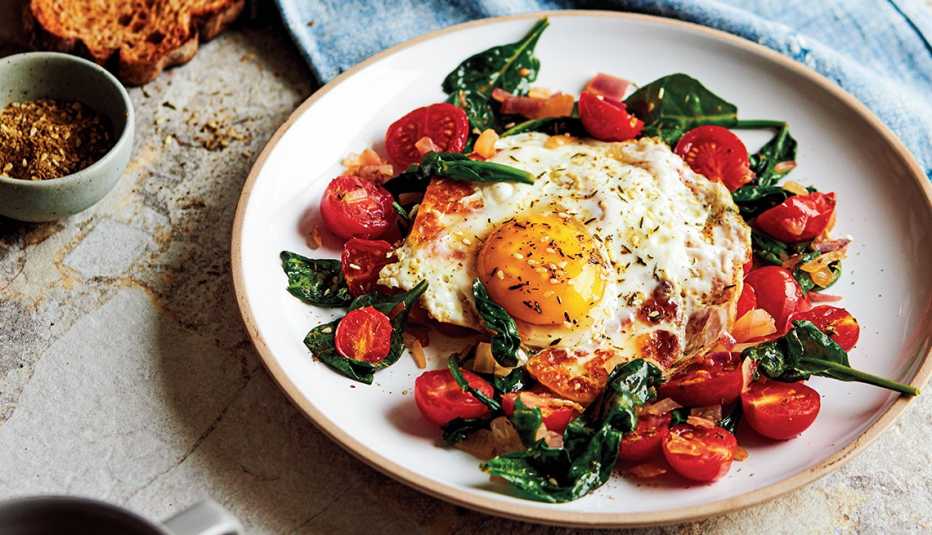 Egg, halloumi, spinach and tomatoes on plate