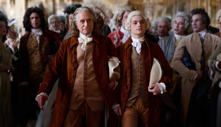 Michael Douglas as Ben Franklin and Noah Jupe leading a group of people in a scene from Apple TV+ miniseries ‘Franklin.’ 