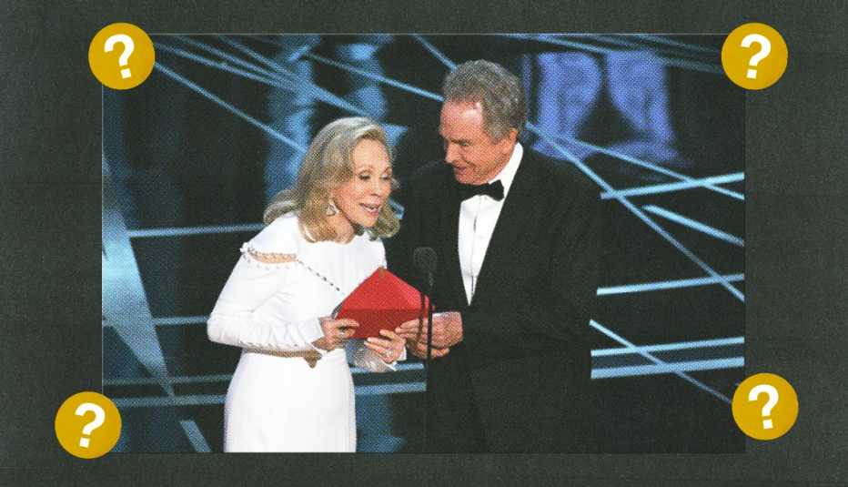 faye dunaway and warren beatty opening envelope at microphone on stage surrounded by gold circles with question marks in them