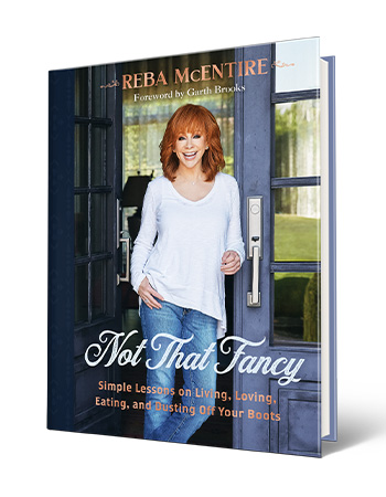 book cover with words reba mcentire, foreword by garth brooks, not that fancy, simple lessons on living, loving, eating, and busting off your boots; picture of reba mcentire on it