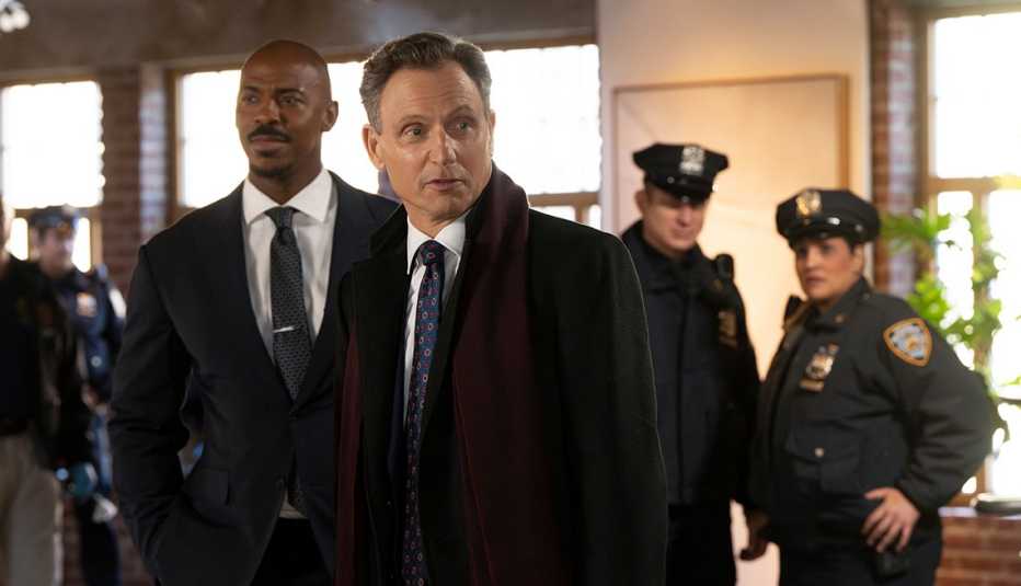 Mehcad Brooks as Detective Jalen Shaw and Tony Goldwyn as District Attorney Nicholas Baxter in a still from Law and Order; police officers in the background