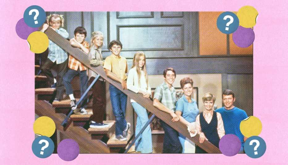 Brady Bunch family and Alice lined up on stairs in their house