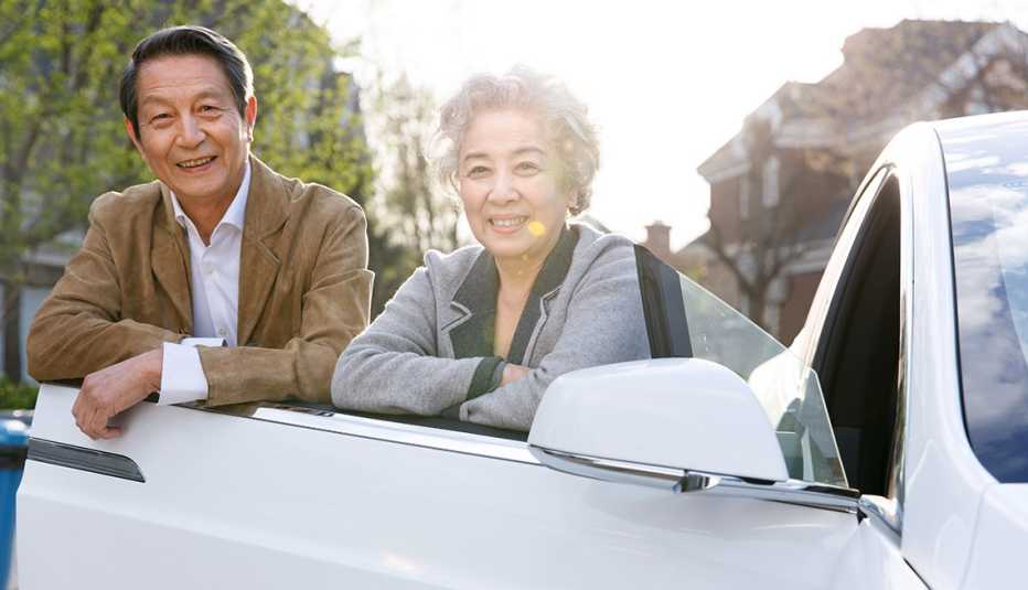 Older couple standing next to car door