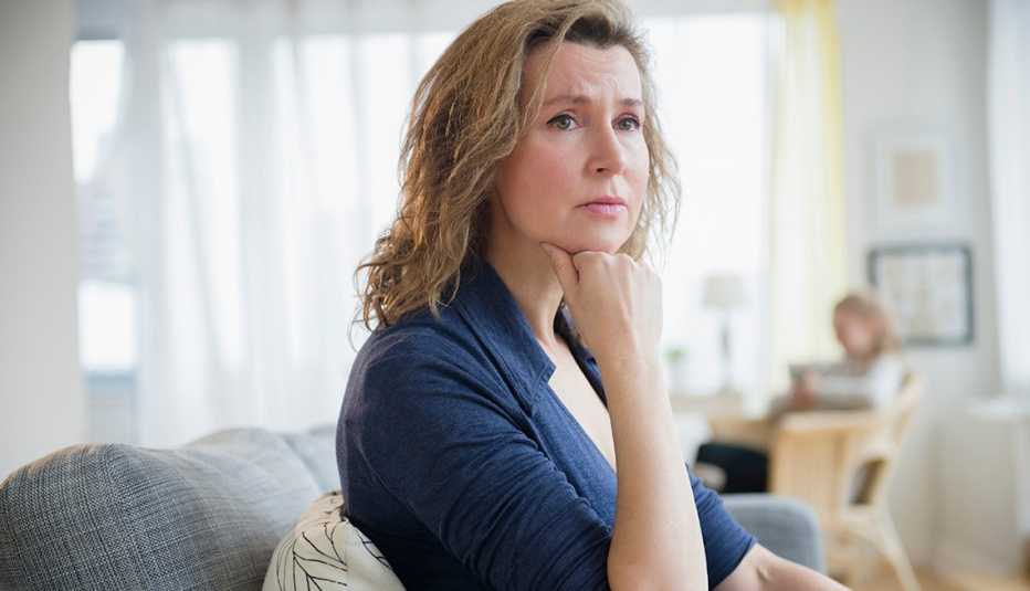 Worried Woman on Couch, Daylight White Curtains, Help for Long-Distance Caregivers 