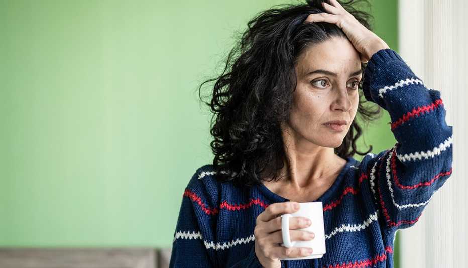 Worried looking woman holding a cup of coffee