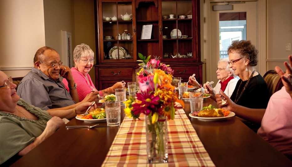 Residents of a household model nursing home eating dinner together