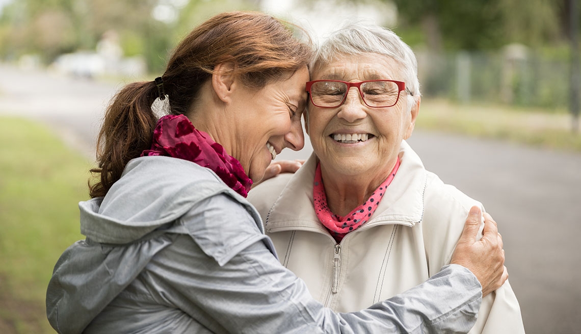 smiling caregiver and woman walking outdoors