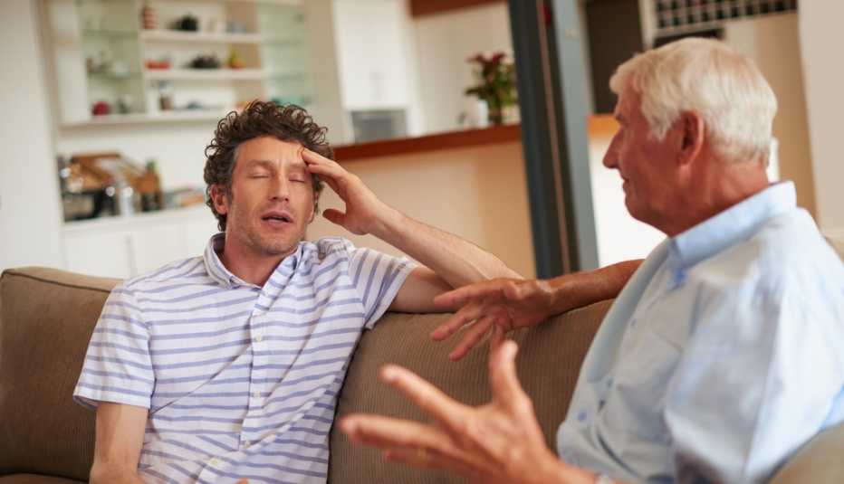 older man and son arguing on couch