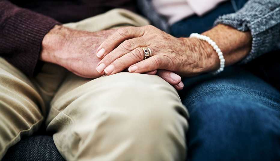 close up of older couple holding hands