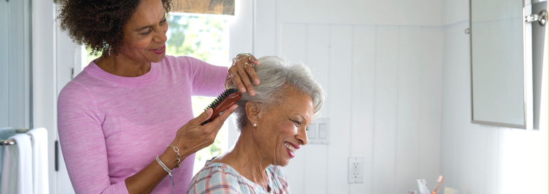a woman is brushing the hair of an older woman