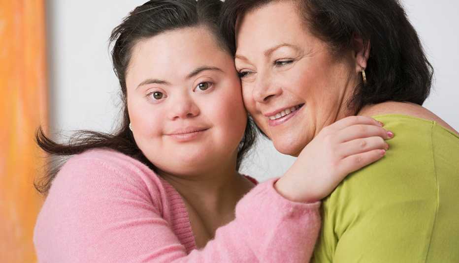 A young woman with down syndrome hugging her mother