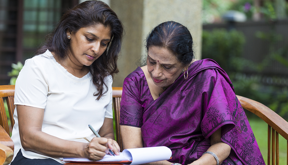 A woman sitting with her mother filling out paperwork to become her mother's legal representative