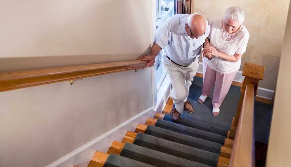Woman helping older man up stairs  