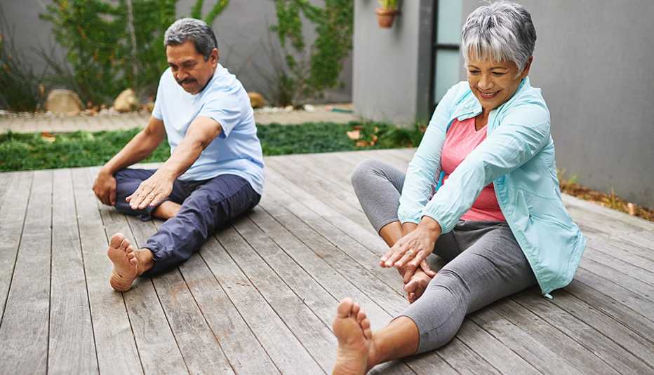 Two older people stretching outdoors