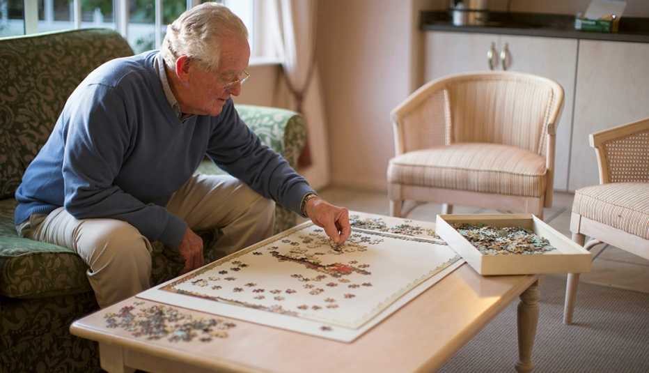 Man in a nursing home staying busy by doing a puzzle his family sent him