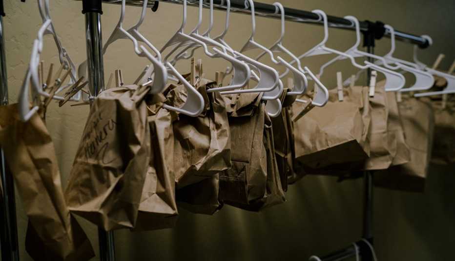 a closet full of hangers holding labeled paper bags one for each nurse face mask