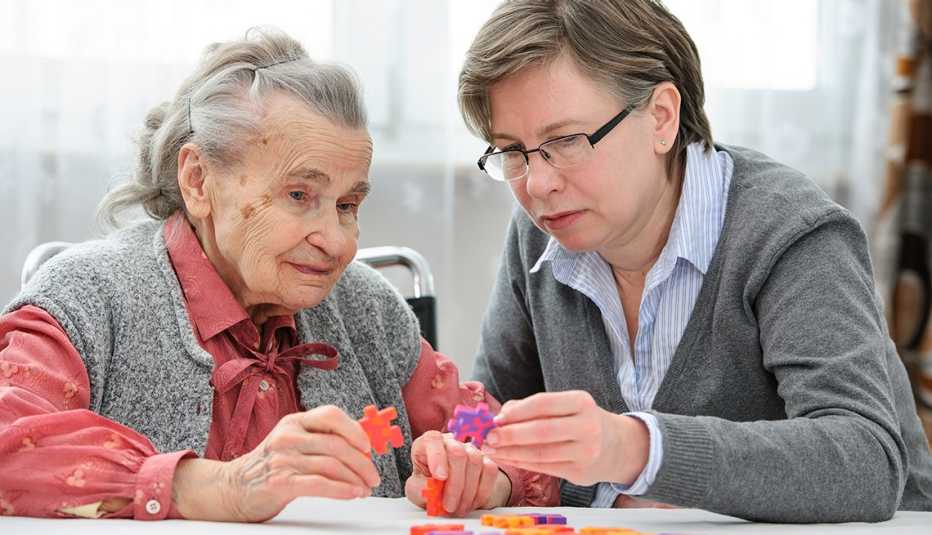 Woman doing a puzzle with her mother who has Alzheimer's