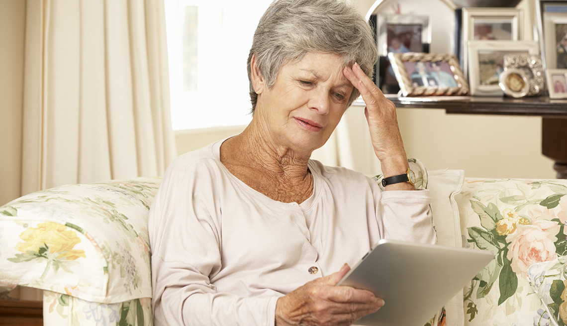 Woman in a nursing home holding a tablet and looking frustrated