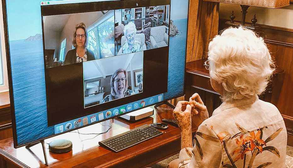 A female nursing home resident in a virtual chat suite visiting with family through the computer