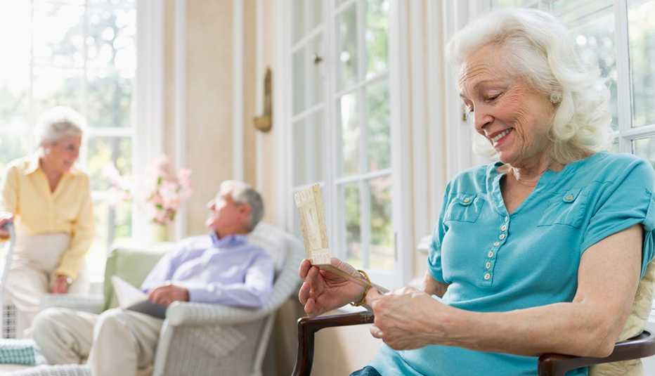 A woman in a nursing home looking at a card she received from a family member