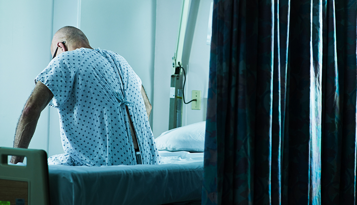 back of a man sitting in a hospital bed