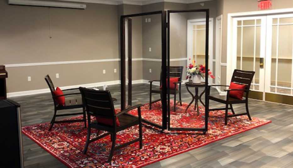  A nursing home family living room with chairs separated by a glass partition