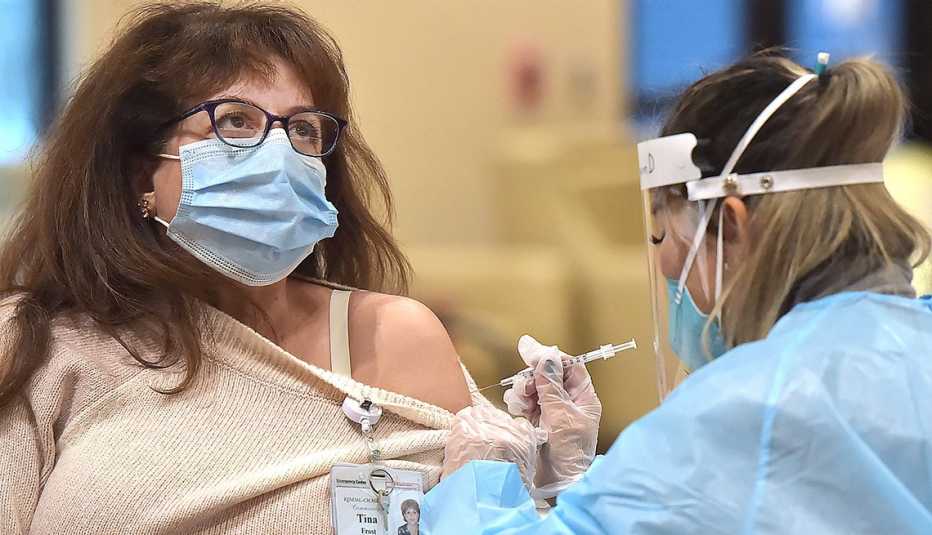 A woman is getting a vaccine from a nurse