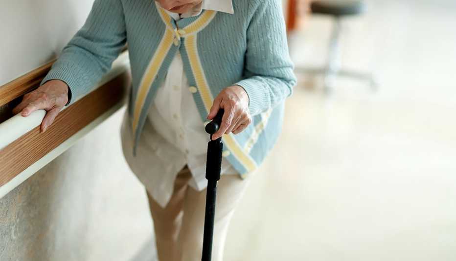 woman walking with walking cane in nursing home