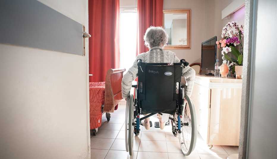 A woman sitting in a wheelchair in her nursing home room