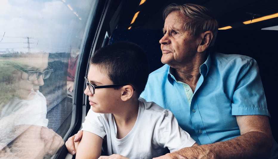 Older man and young boy traveling in a train looking out the window