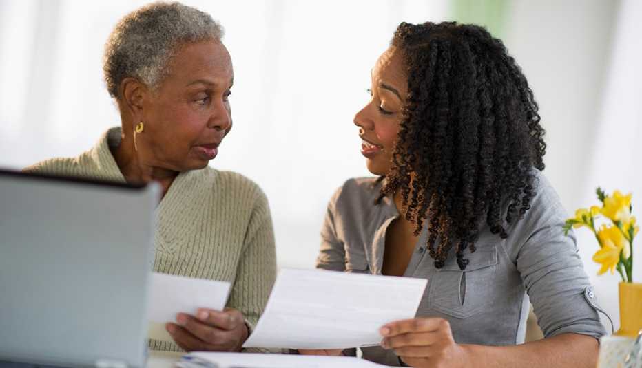 Mom and adult daughter sitting at a table reviewing legal paperwork