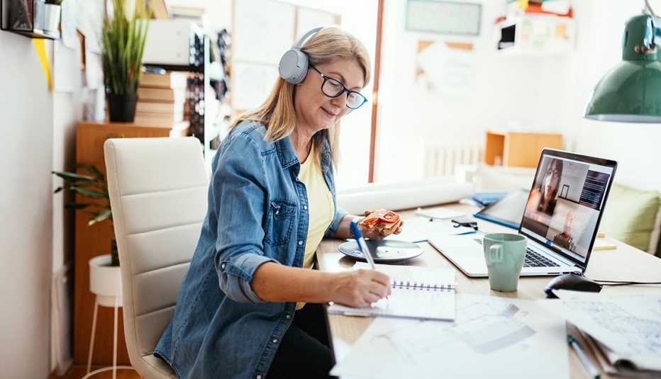 A woman wearing headphones while working from home