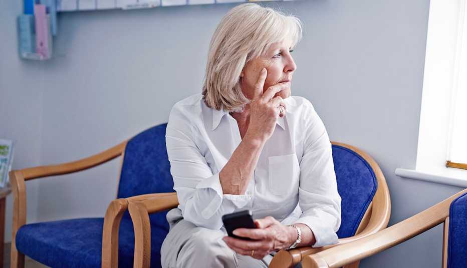 woman on her phone in a hospital seating room