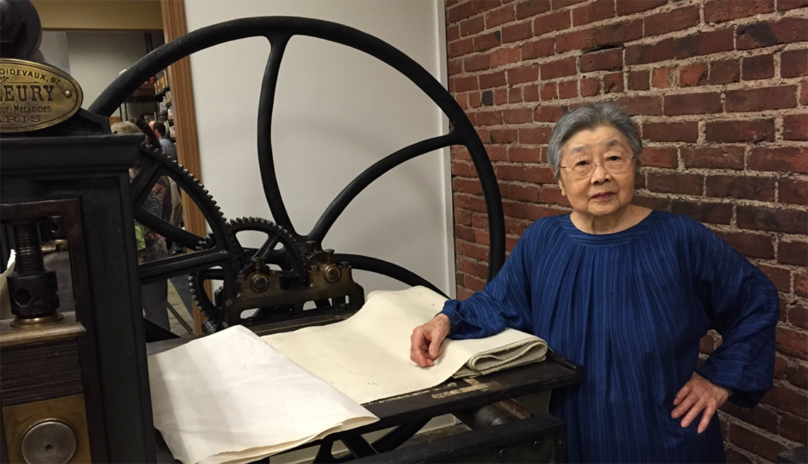Jean Kubota Cassill standing next to an historic French printing press