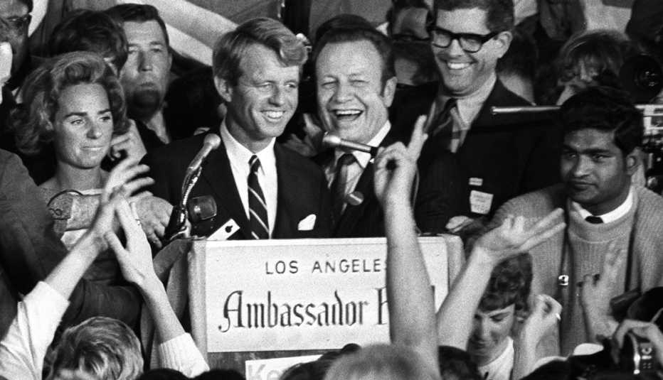Robert F. Kennedy standing at a podium, sign in front reads Los Angeles Ambassador Hotel
