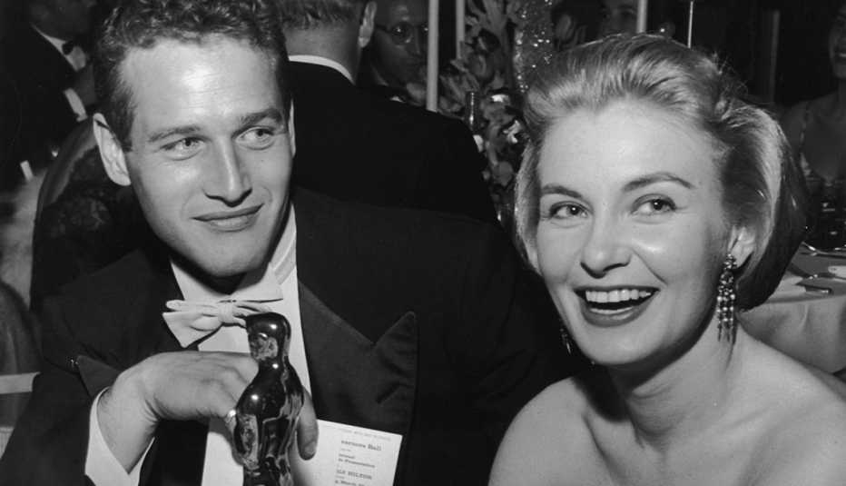 American actor Joanne Woodward holds her Oscar statuette while sitting next to husband, American actor Paul Newman, during the Governor's Ball, an Academy Awards party held at The Beverly Hilton Hotel, Beverly Hills, California. Woodward won the Best Actress Oscar for director Nunnally Johnson's, 'The Three Faces of Eve.' 