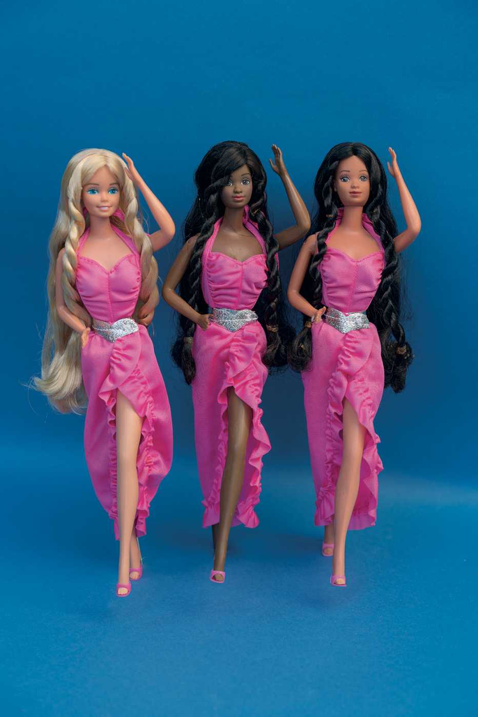 3 barbie dolls wearing pink dresses with a twisty curl hairstyle