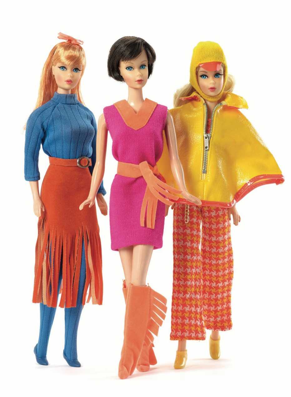 2 barbie dolls with fringe clothing and another barbie doll wearing a yellow poncho
