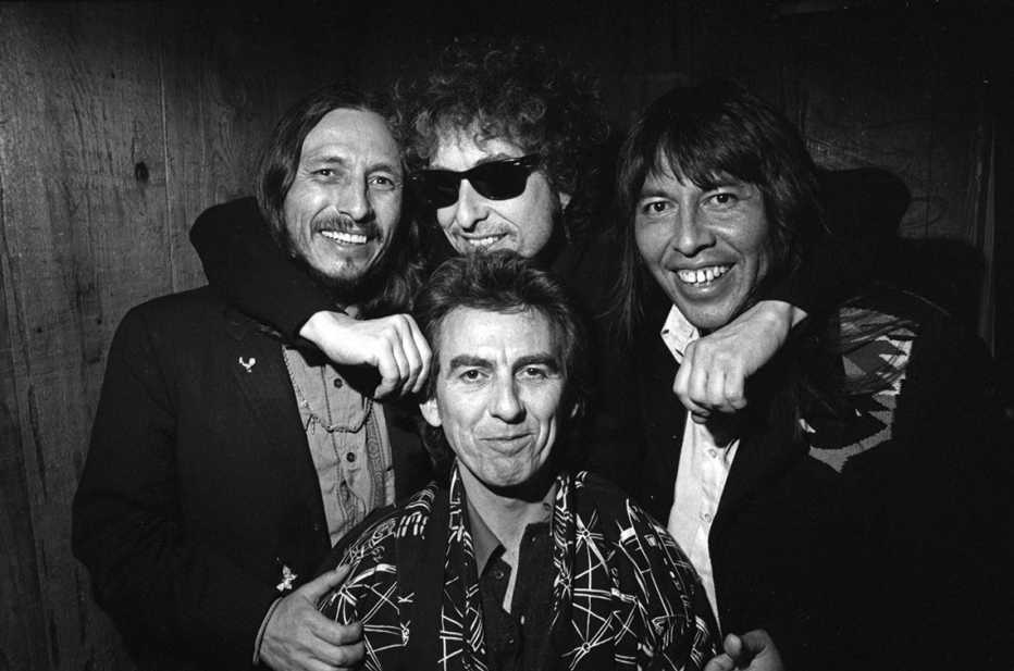 bob dylan with george harrison john trudell and jesse ed davis at a los angeles concert in nineteen eighty seven