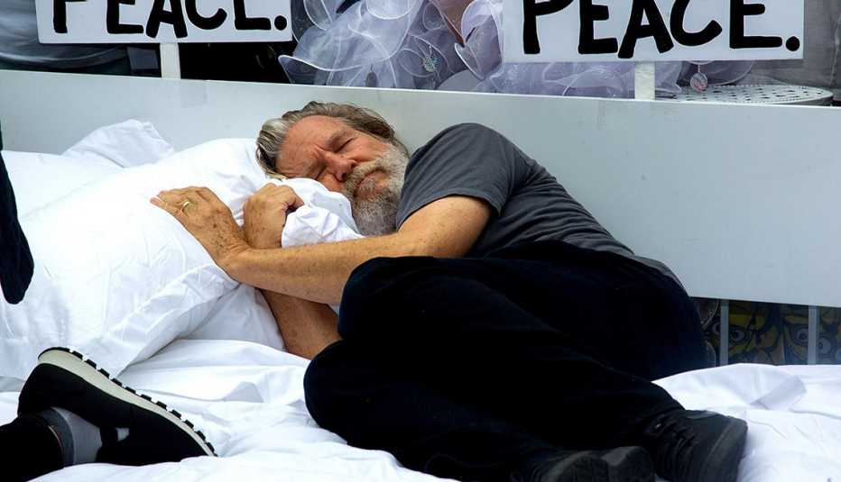 Jeff Bridges laying on a bed for a charity event in NYC