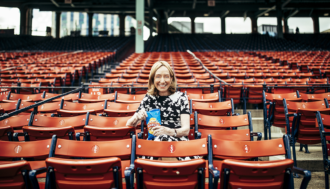 doris kearns goodwin sits in the stands of an empty baseball stadium holding a bag of peanuts